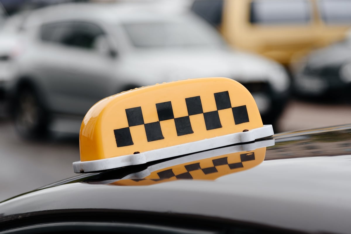 Señal de taxi sobre una calle de la ciudad